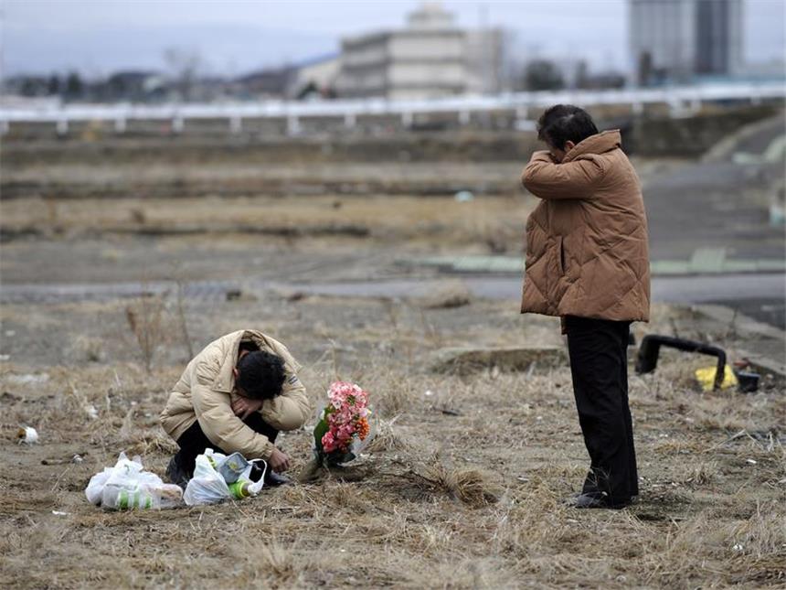 Japan und die Welt gedenken der Tsunami- und Atomtod-Opfer Frauen weinen an dem Ort, wo ihr Haus vor der Katastrophe stand. Foto: Franck Robichon