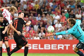 Freiburgs Torwart Alexander Schwolow (r) kann einen Schuss auf sein Tor abwehren. Foto: Bernd Settnik