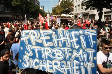 „Freiheit stirbt mit Sicherheit“ steht auf dem Schild von Demonstranten in Düsseldorf. Foto: David Young