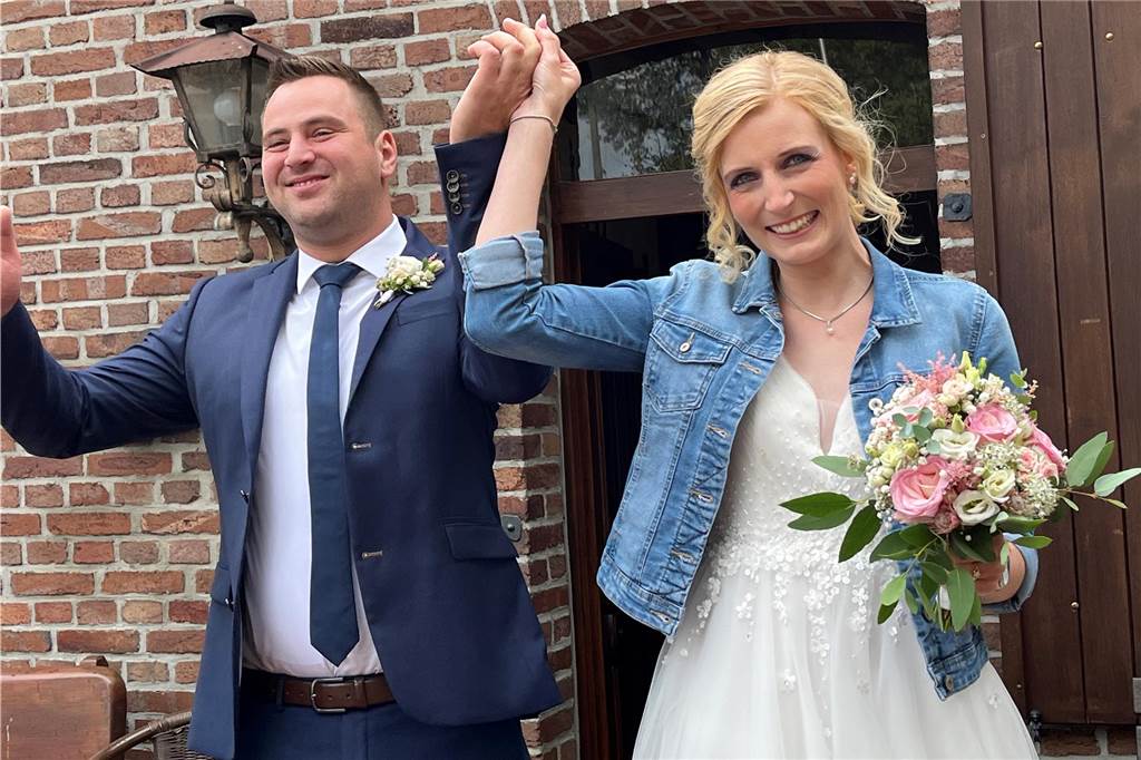 Brautpaar winkt seinen Gästen.