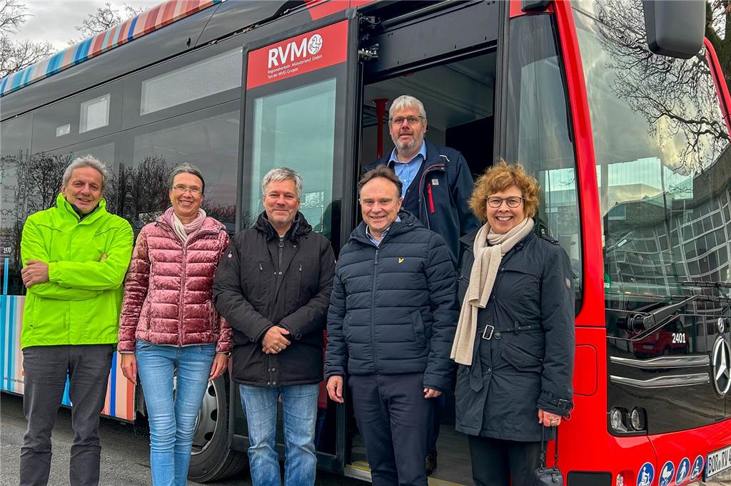 Erste E-Busse mit besonderer Optik auf Tour: Premiere auf Buslinie R76/77 Gruppe vor einem Bus