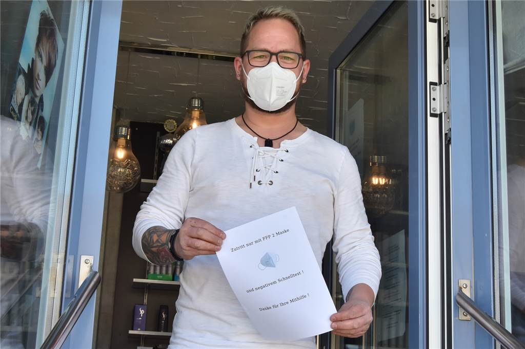 Schnelltest vor dem Friseurbesuch: „Das ist für uns eine Katastrophe“ Friseurmeister Jörn Moschinski hängt einen Zettel mit Hinweis auf die FFP2-Masken- und die Schnelltest-Pflicht an die Tür. Auch er hat schon Absagen bekommen.
