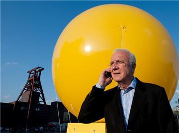 Fritz Pleitgen auf dem Gelände der Zeche Zollverein in Essen vor einem der gelben Gasballons des Kulturhauptstadtprojektes «Schachtzeichen».