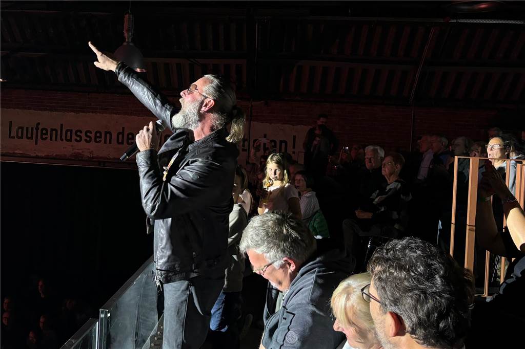 Über 700 Besucher feierten Kultband K.R.A.S.S. in der Rohrmeisterei Frontmann und Sänger Holger Auer zeigt singend in Richtung des Publikums.