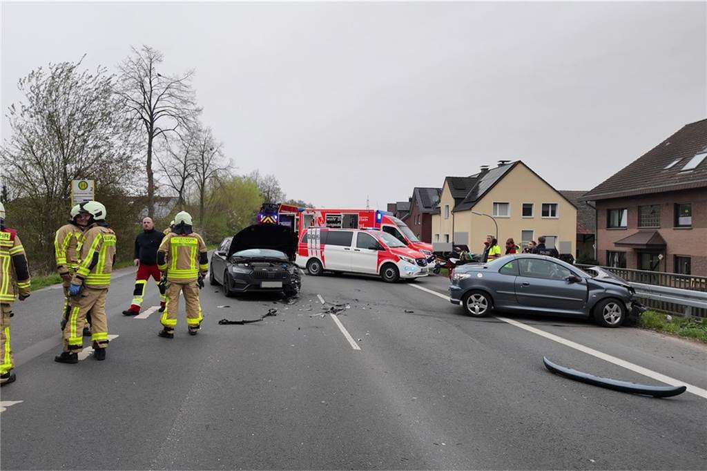 Eine Unfallstelle in Waltrop. Im Hintergrund sind Einsatzfahrzeuge der Feuerwehr zu sehen. Feuerwehrleute stehen am linken Bildrand.