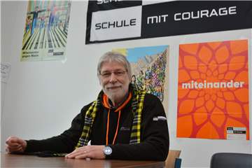 Für ein „Miteinander gegen Nazis“ und eine „Schule mit Courage“ werben Plakate im Raum der Schülervertretung. Hier fühlt sich Bert Baesgen absolut wohl, denn gerade für das Engagement hat er sich stets engagiert. Auch der BVB-Schal passt perfekt zu ihm, Baesgen ist seit Jahren Dauerkarten-Besitzer.