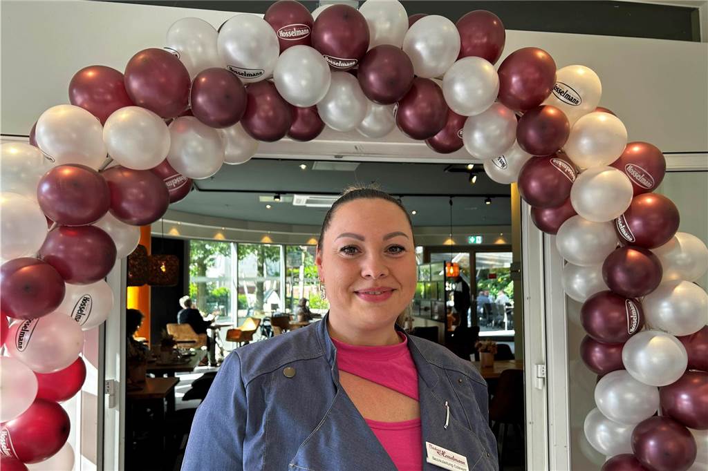 Hosselmann-Bezirksleiterin Kristina Özlevent steht vor dem mit Ballons geschmückten Durchgang zum Café
