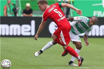 Fürths Julian Green (r) verpasst gegen Sandhausens Denis Linsmayer den Ball. Foto: Karl-Josef Hildenbrand