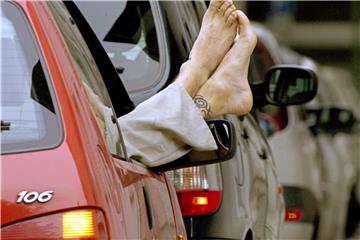 Füße aus dem Fenster: Wer als Beifahrer nicht normal sitzt, muss bei einem Unfall mit einer Mithaftung rechnen. Foto: Katharina Ebel/Symbolbild