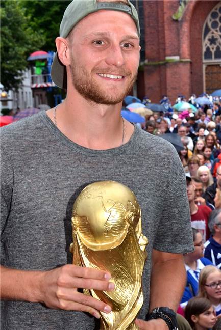 Fußball-Weltmeister Benedikt Höwedes, hier mit einem Modell des WM-Pokals.