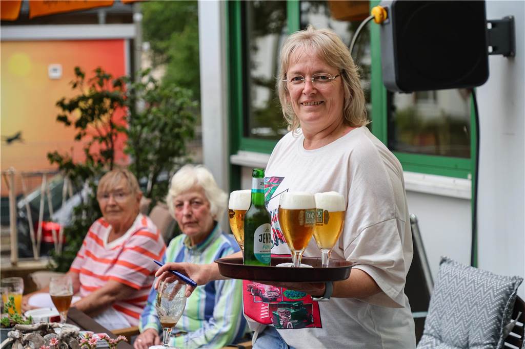 In diesen Kneipen läuft das Finale: Eine verteilt kostenlose Würstchen Wirtin Gabriele Steinmann trägt ein Tablett voller Bier durch ihren Biergarten.