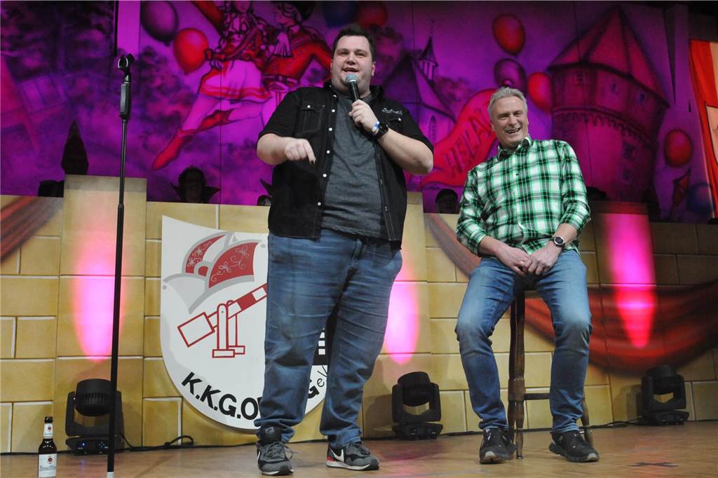 Kappenball der KKG Oeding: Eine närrische Zeitreise in die 1960er Jahre Besucher Bodo und Comedian Thorsten Dornbach auf der Bühne.