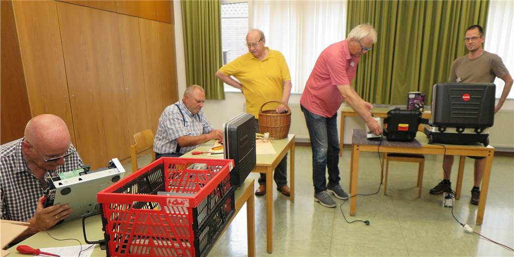 Wegwerfen war gestern: Reparatur-Service hilft Schermbeckern Menschen sitzen an Holzbänken und reparieren Gegenstände.
