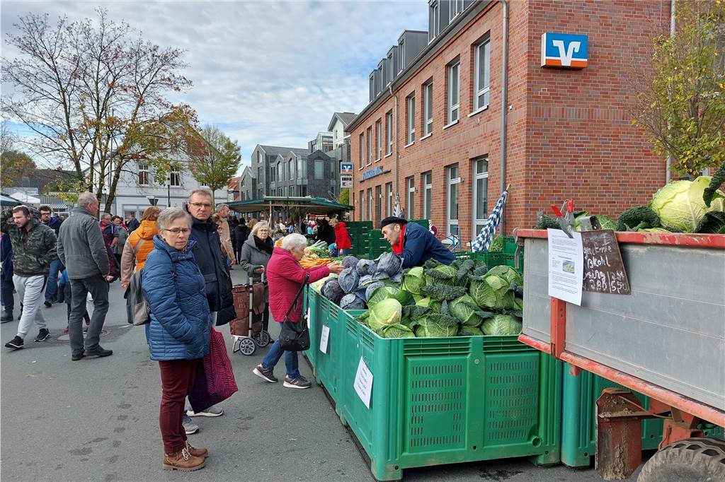 Kappesmarkt Raesfeld 2022: Die besten Bilder Menschen stehen auf dem Raesfelder Kappesmarkt vor einer großen Kiste mit Kohl.