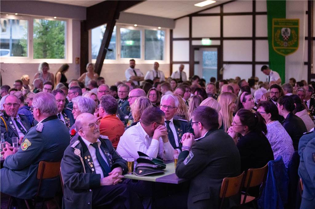 Viele Menschen der Schützenvereine sitzen an Bierzeltgarnituren im Festzelt. Es ist sehr voll.