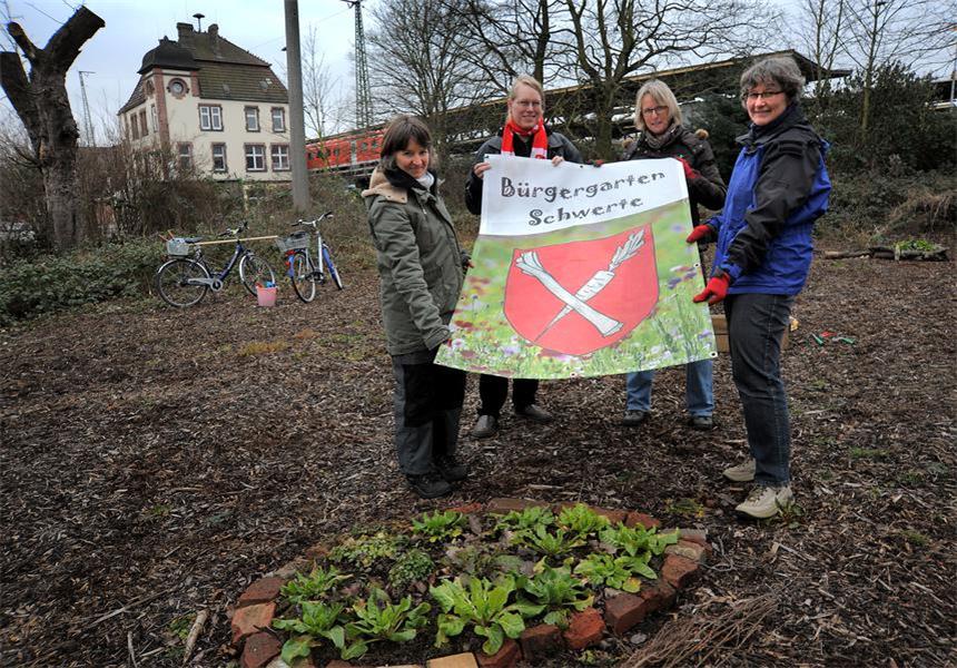 Urbane Gartenarbeit am Schwerter Bahnhof Gemüse als Bürgergarten-Wappen.