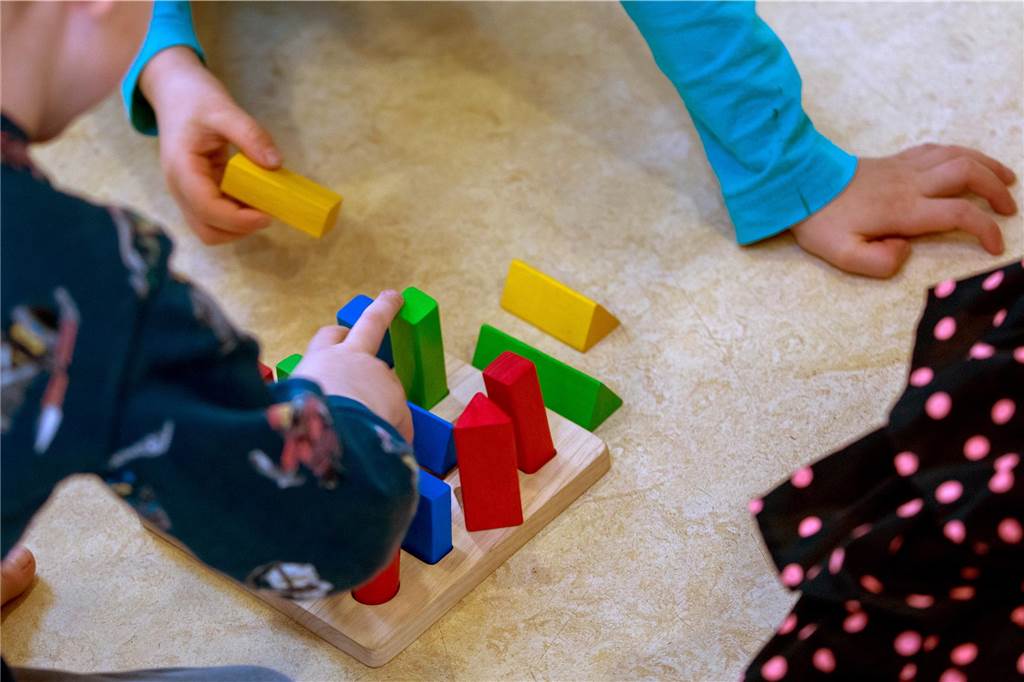 Tagesmütter klagen: „5,81 Euro pro Kind und Stunde sind zu wenig“ Kinder spielen mit Holzklötzchen.