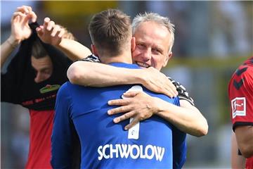Gerettet: Freiburg-Coach Christian Streich feiert mit Keeper Alexander Schwolow (v) den Klassenerhalt. Foto: Patrick Seeger