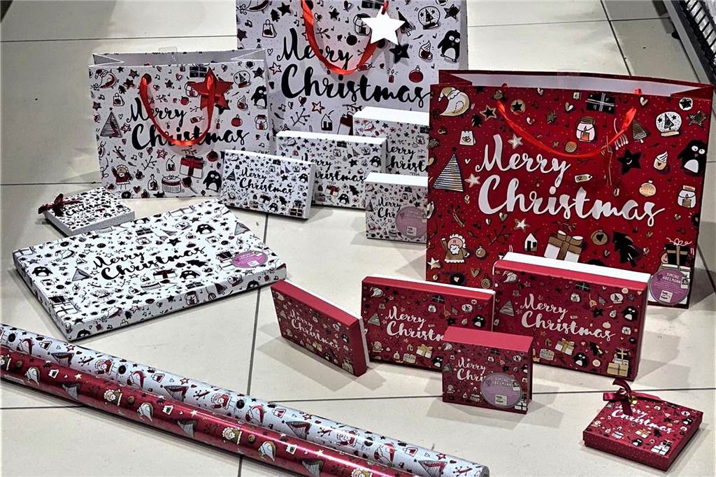 Woolworth: Geschenkpapier von Simone Abelmann hilft Familien Geschenkpapier und -tüten mit Scetchnotes liegen auf einem Boden.