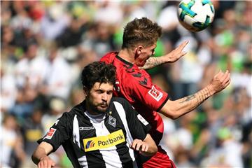 Gladbachs Tobias Strobl (l) und Freiburgs Tim Kleindienst kämpfen um den Ball. Foto: Federico Gambarini