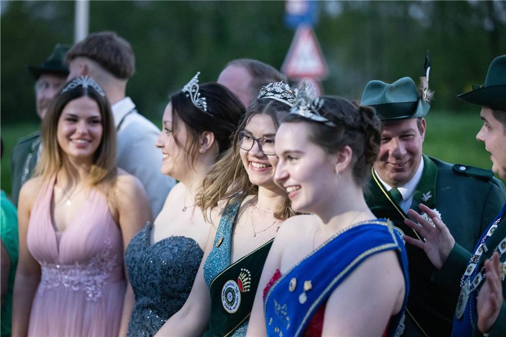 Mehrere Schützenköniginnen mit schönen Kleidern und Diademen strahlen vor Lachen.