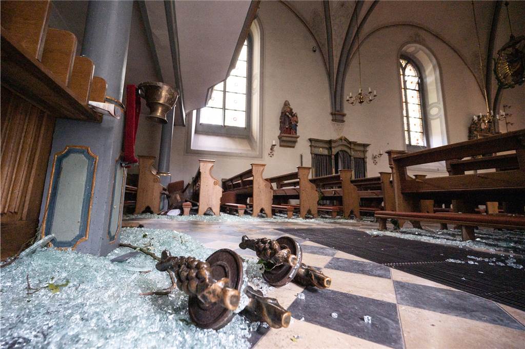 Tornados in NRW: Luftbilder zeigen Ausmaß der Zerstörung - „Ich habe Menschen weinen sehen“ Glassplitter und die Türgriffe eines gläsernen Windfangs liegen in der katholischen Kirche St. Clemens im Ortsteil Hellinghausen in Lippstadt.