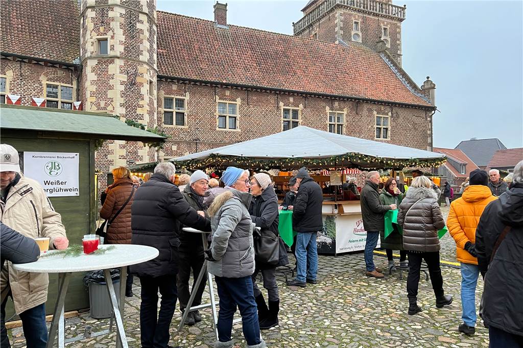 Raesfelder Adventsmarkt 2022: So weihnachtlich war der Auftakt Menschen trinken Glühwein auf dem Innenhof des Wasserschlosses.
