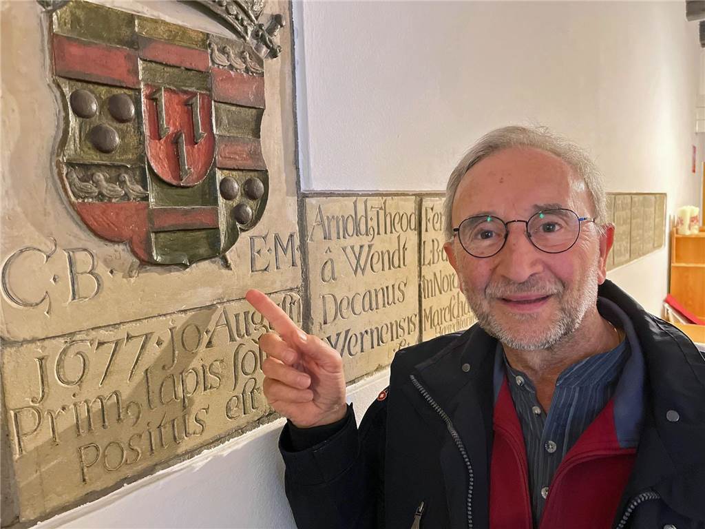 Gregor Zumholz zeigt auf den offiziellen Grundstein für die Klosterkirche mit dem Wappen des Fürstbischofs von Münster. Die lateinische Inschrift lautet übersetzt: "Unter dem Bischof von Münster, Christoph Bernard von Galen, wurde am 10. August 1677 der erste Stein feierlich gelegt."