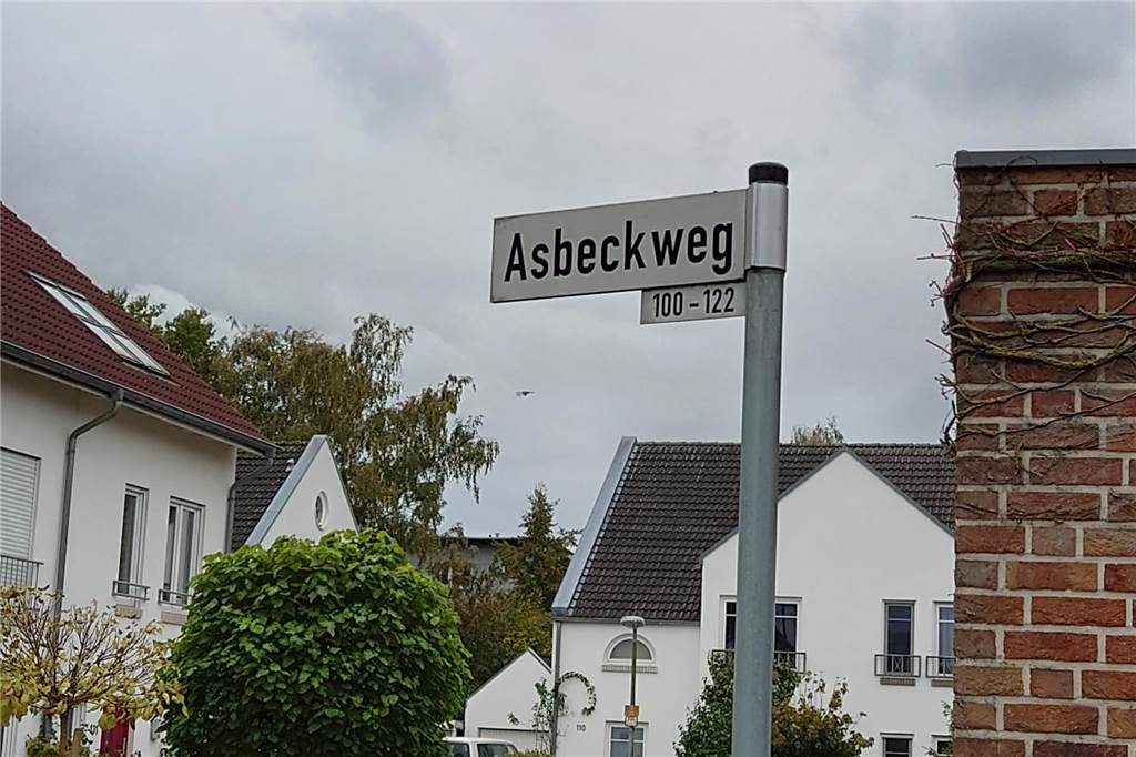 Straßennamen in Münster geben manches Rätsel auf Ein Straßenschild mit der Aufschrift Asbeckweg neben einer Mauer