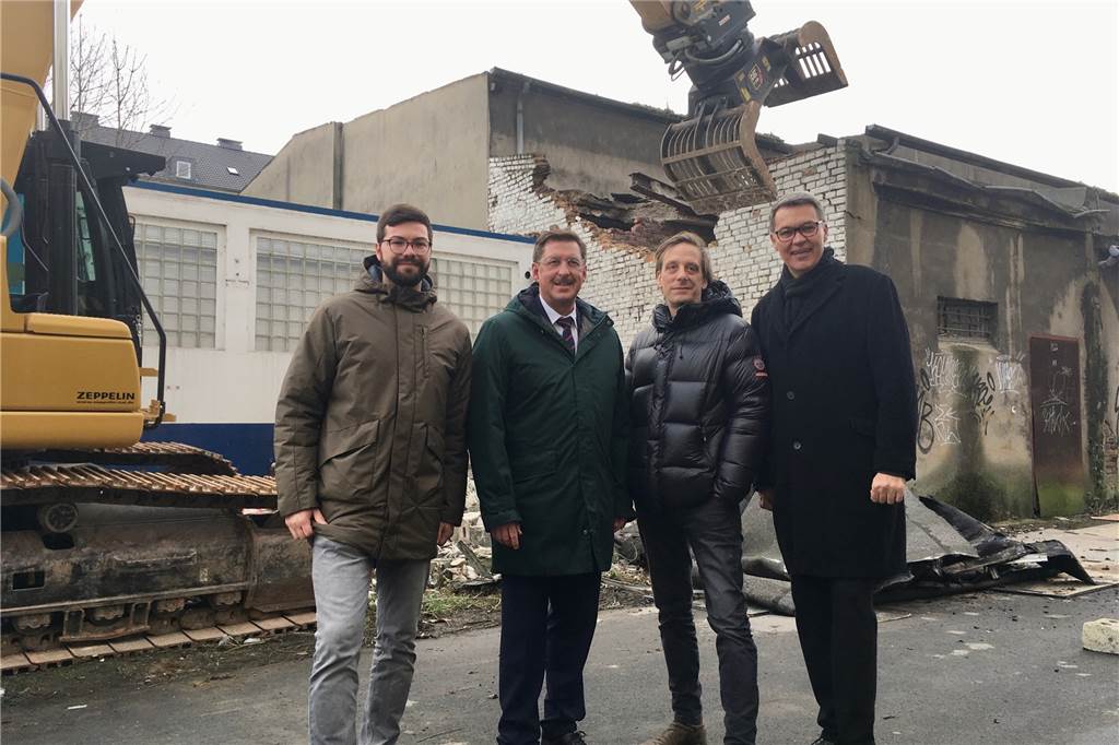 Mit Video: Abriss an der Speicherstraße im Dortmunder Hafen hat begonnen Gruppenbild mit Bagger: Torben Wortmann (v.l.) vom Abrissunternehmen DOLOG, Hafen-Chef Uwe Büscher, Schauspiel-Chef Kay Voges und Wirtschaftsförderungs-Chef Thomas Westphal freuen sich über den Beginn der Bauarbeiten an der Speicherstraße.