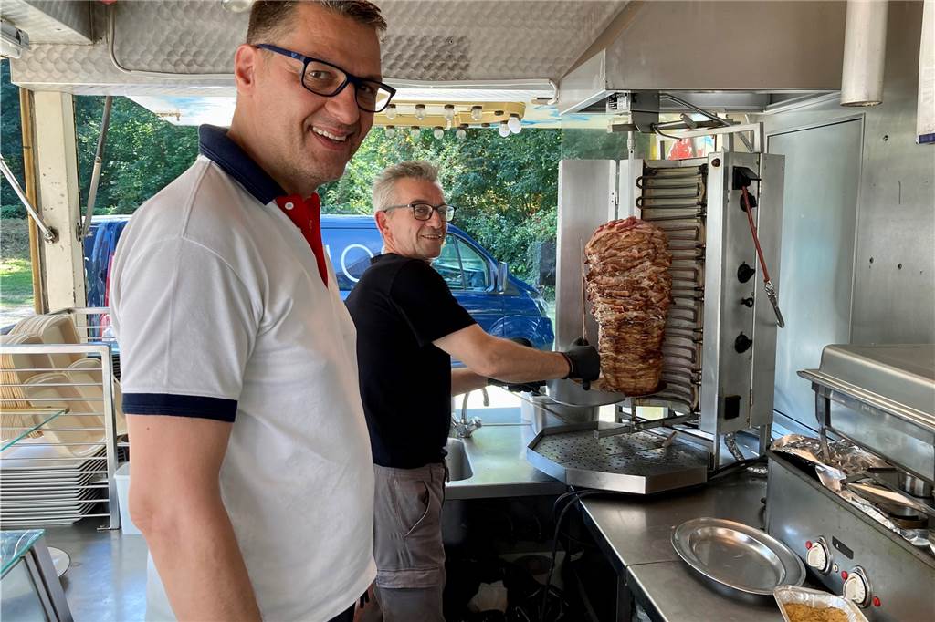 Zwei Köche auf dem Kantinenwagen mit Gyrosspieß.