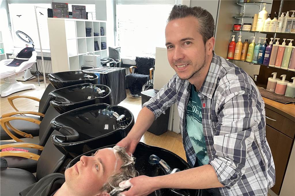 Friseurmeister David Ehwein schließt Salon und wird digitaler Manager Das Foto zeigt Friseurmeister David Ehwein beim Haarewaschen in seinem Salon.