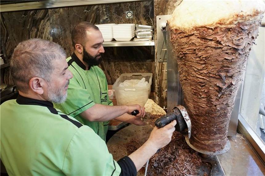 50 Jahre Döner Kebab – Wie ein Gesetz zur Verbreitung in Deutschland beitrug Halit (l) und Halip vom Imren Grill in Berlin bereiten einen Döner zu. Vor fünfzig Jahren soll er erfunden worden sein.