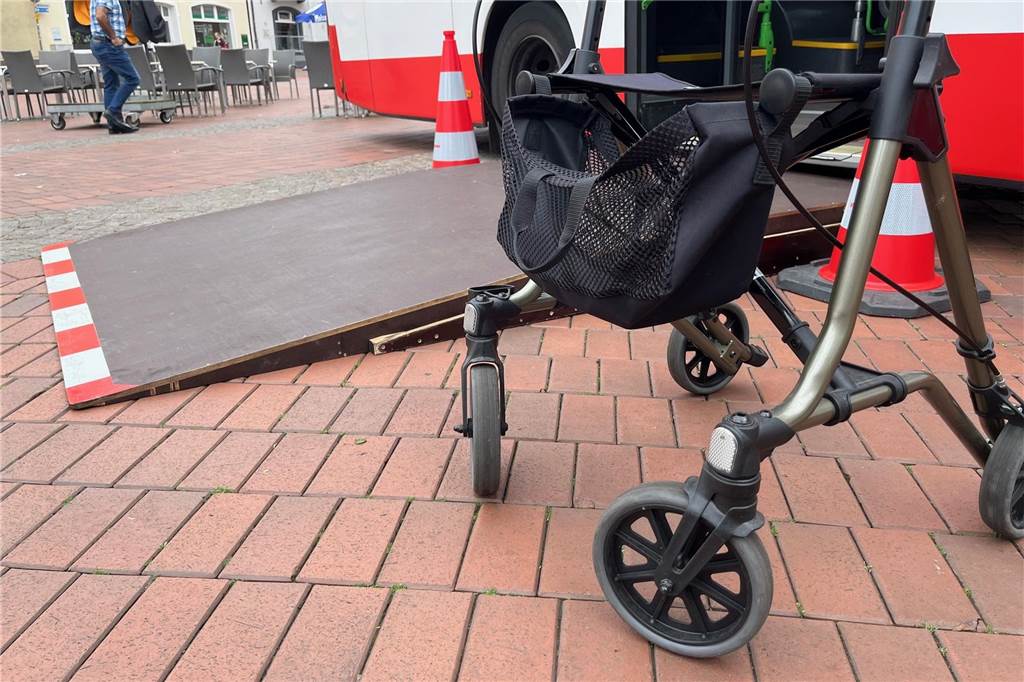 Senioren lernen Tipps und Tricks bei Rollatorentraining Rollator vor Bus