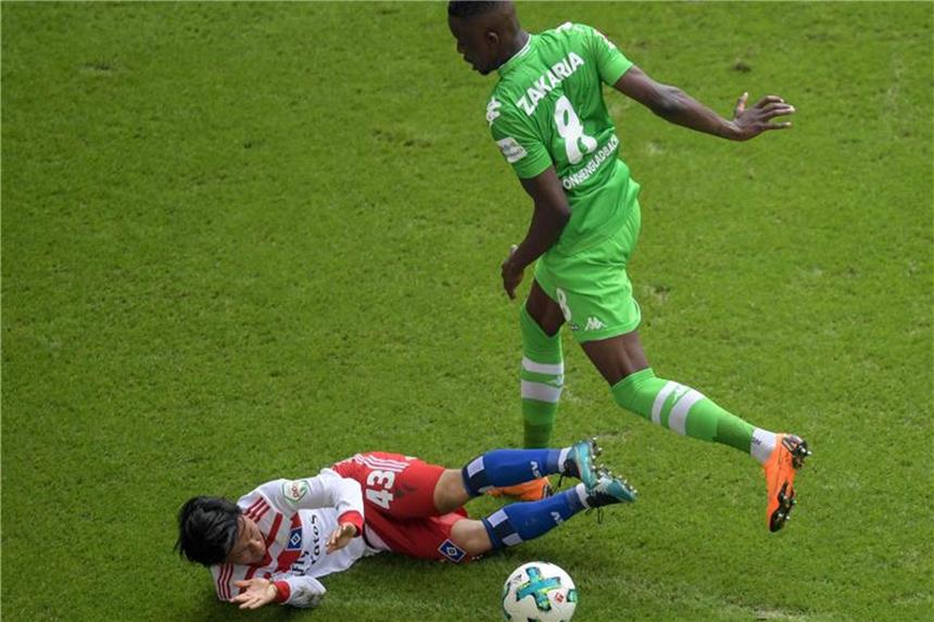 HSV siegt und steigt ab - Krawalle beim Abschied Hamburgs Tatsuya Ito (l) spitzelt Mönchengladbachs Denis Zakaria den Ball vom Fuß. Foto: Axel Heimken