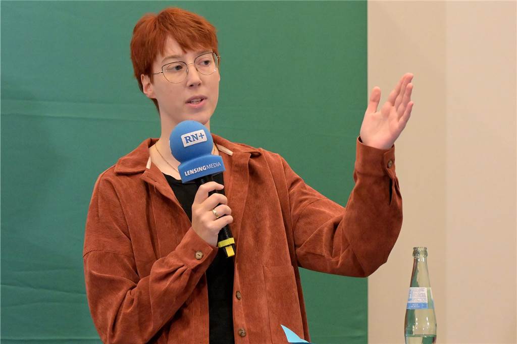 „Nicht jeder Mensch hat das Recht auf Asyl in Deutschland“ Hanna Hüwe von den Grünen hält ein Mikrofon in der Hand.