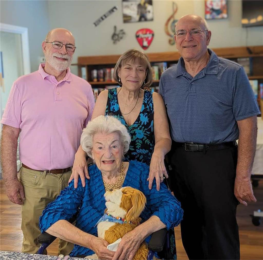 Holocaust-Überlebende Hannelore Adler feiert 99. Geburtstag Hannelore Adler sitzt auf einem Stuhl im Kreise ihrer Familie.