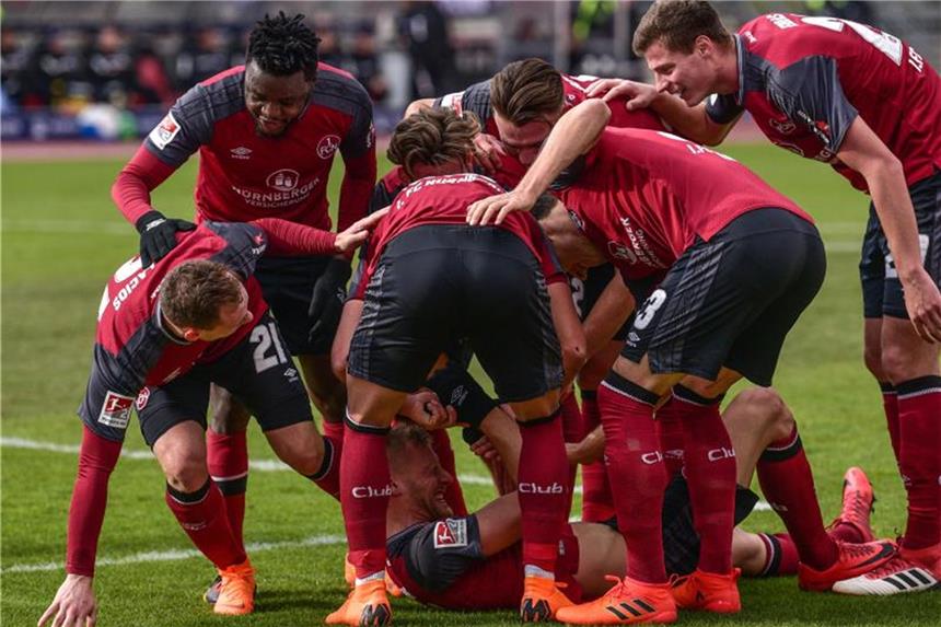 Nürnberg nach 3:1 gegen Duisburg Zweitliga-Tabellenführer Hanno Behrens (unten) wird von seinem Team für seinen 2:0 Treffer gefeiert. Foto: Nicolas Armer