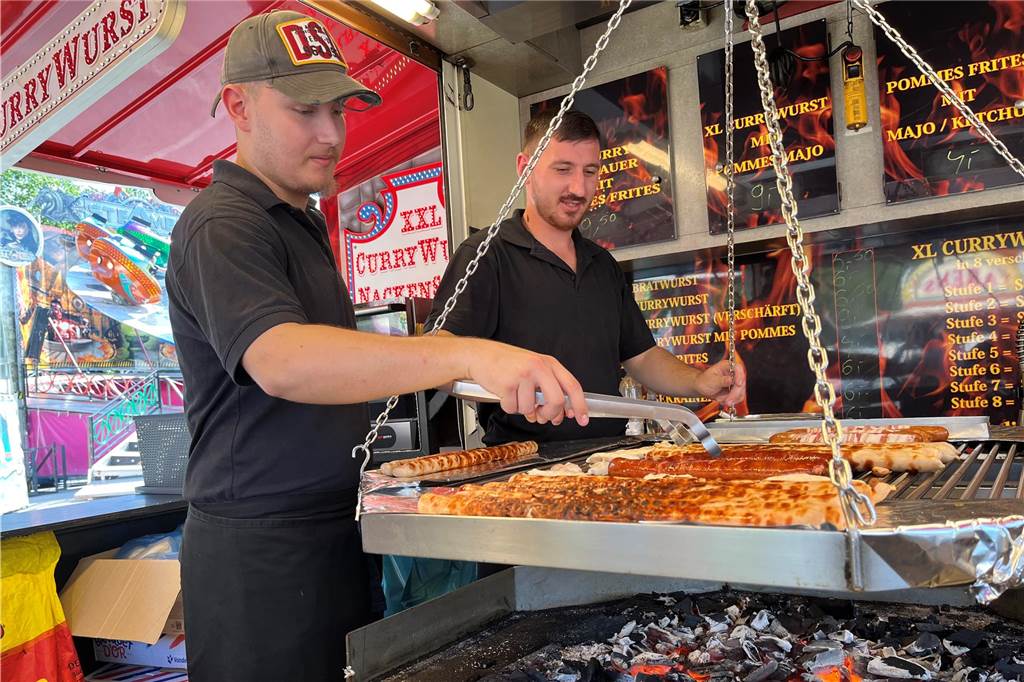 Lünsche Mess bei fast 30 Grad in Lünen: Schausteller: „Das müssen wir leider aushalten“ Hans (links) steht im Schwenkgrill und könnte den vielleicht heißesten Arbeitsplatz auf der Lünsche Mess haben.