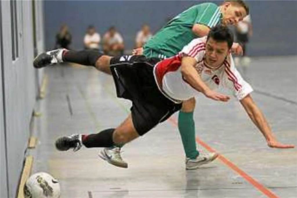 Der letzte Hallentitel von Gurbet Spor Bergkamen Zweikampf im Hallenfußball. Ein Spieler fällt hin.