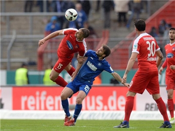 Heidenheims John Verhoek (l) im Kopfballduell gegen Karlsruhes Gaetan Krebs. Foto: Deniz Calagan
