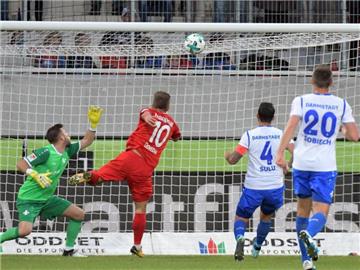 Heidenheims Nikola Dovedan (M.) erzielt das 1:0 gegen Darmstadts Torwart Daniel Heuer Fernandes. Foto: Stefan Puchner