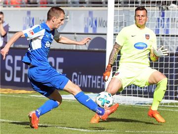 Heidenheims Torwart Kevin Müller (r) klärt gegen den Kieler Dominik Drexler. Foto: Stefan Puchner