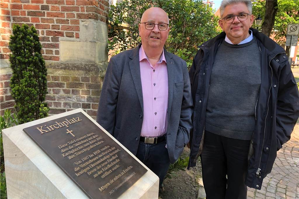 Bronzetafeln informieren über die Geschichte von Kirche und Kirchplatz Heimatvereinsvorsitzender Ernst Bennemann und Pastor Stefan Scho an der Sandsteinstele mit Bronzetafel. Auf der Tafel steht Wissenswertes über die Geschichte des Kirchplatzes.