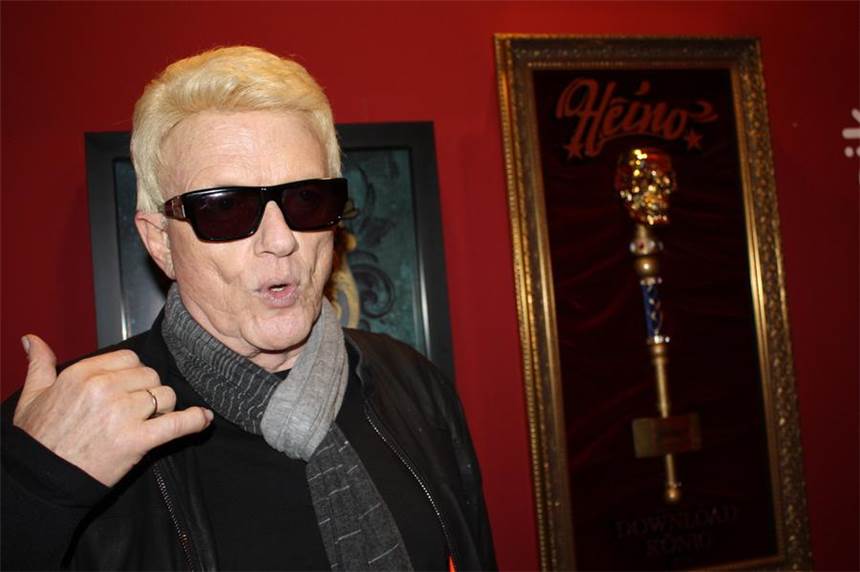 Schlagerstar Heino besucht Schlagerausstellung Heino erzählt, dass die jungen Leute heutzutage ja nur noch mit ihren Handys Songs runterladen. Neben ihm prangt der Starwatch-Platin-Award, den er für die vielen legalen Downloads des Albums "Mit freundlichen Grüßen" bekam.