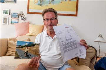Heinz-Dieter Hoffmann mit dem Schreiben seines Vermieters und einem Foto, auf dem die Radtaschen zu sehen sind.