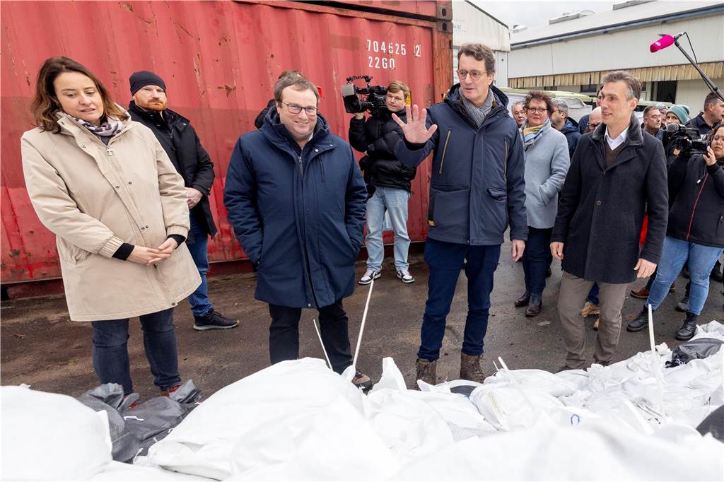 Hochwasserlage in NRW weiter angespannt, aber stabil: Schnee und Glätte in den nächsten Tagen Hendrik Wüst (CDU, Mitte r), Ministerpräsident von Nordrhein-Westfalen, und Oliver Krischer (B90/Grüne) schauen sich mit Vertretern des Unternehmens ReKu, lokalen Politikern und Mitgliedern der Hilfsorganisationen die Hochwasserschutzmaßnahmen auf dem Gelände eines Unternehmens an, hier wurden 16000 Sandsäcke ausgelegt. Ministerpräsident Wüst be...