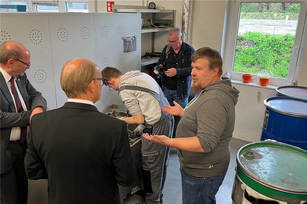 Mitarbeiter der Caritas erklärt, wie in der Werkstatt die Asche von Verstorbenen durchsucht wird, um künstliche Hüften und Ähnliches zu recyclen.