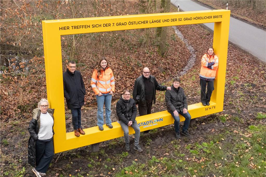 einige Menschen stehen und sitzen am Bilderrahmen