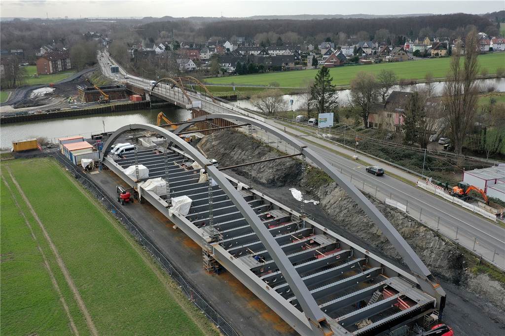 Bögen für Kanalbrücke Gahmener Straße: Noch ruhen sie auf Gerüsten Hinten ist die alte Kanalbrücke zu erkennen, vorne wird an Land die neue Brücke zusammengebaut.